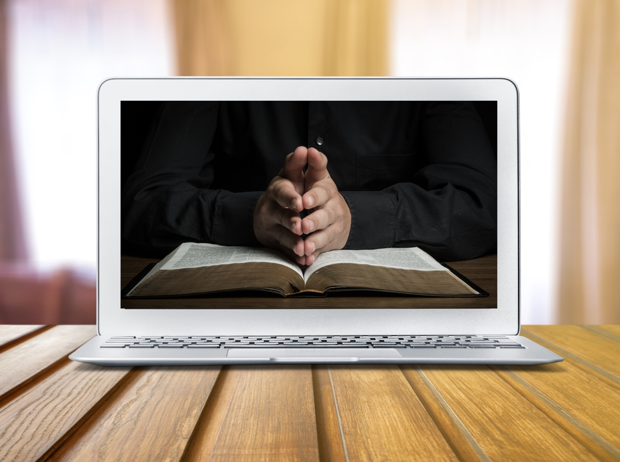 Online live church concept laptop screen with prayer hands